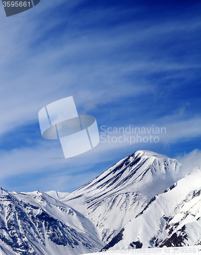 Image of Winter snowy mountains in sun windy day