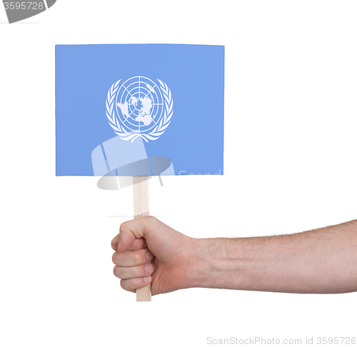 Image of Hand holding small card - Flag of the UN