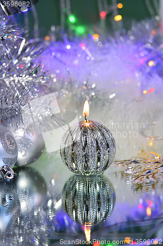 Image of Christmas decorations with candle and silver balls.