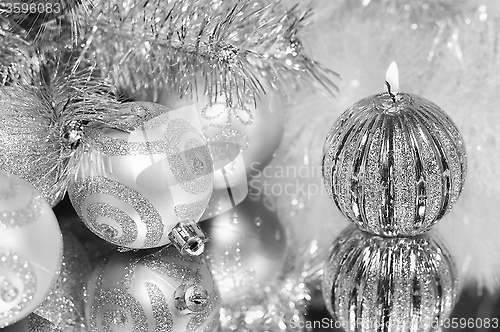 Image of Christmas decorations with candle and silver balls.