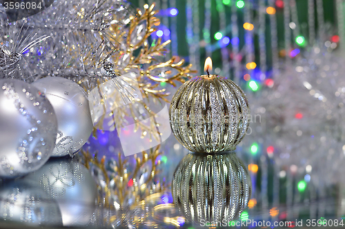 Image of Christmas decorations with candle and silver balls.