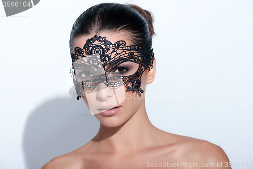 Image of Woman with evening smokey makeup and black lace mask