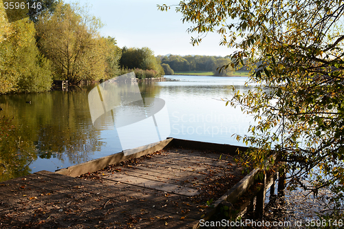 Image of Wooden jetty in fall looks out over a lake