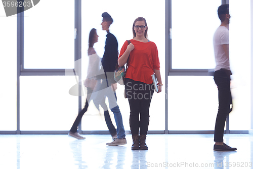 Image of student girl standing with laptop, people group passing by