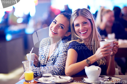 Image of girls have cup of coffee in restaurant
