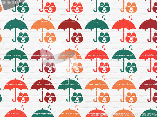 Image of Protection concept: Family And Umbrella icons on wall background