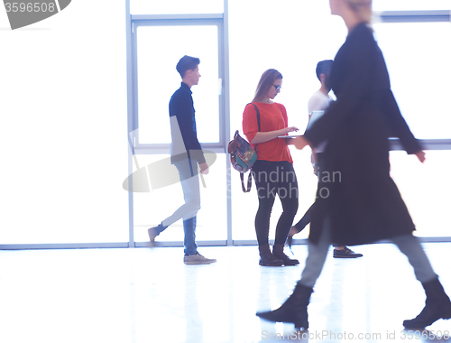 Image of student girl standing with laptop, people group passing by