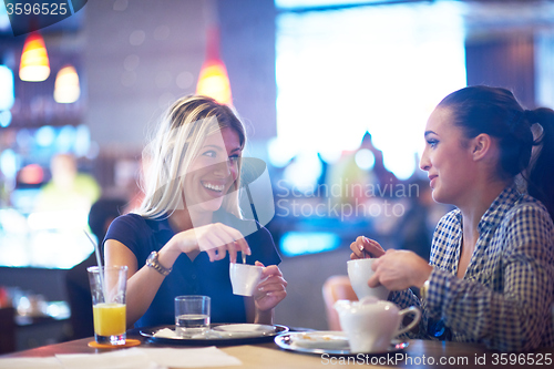 Image of girls have cup of coffee in restaurant