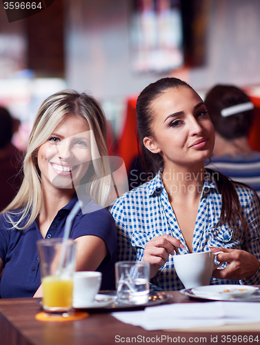 Image of girls have cup of coffee in restaurant