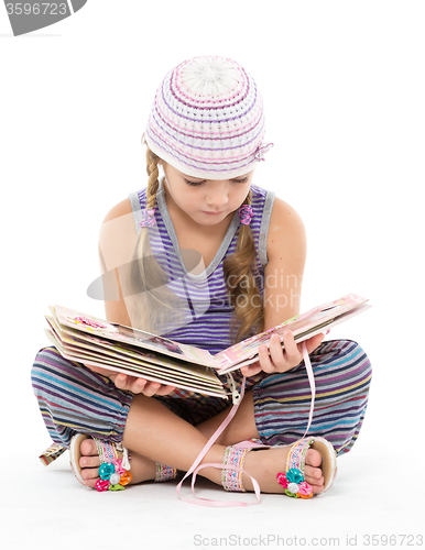 Image of Little Girl Looking Album Sitting on the Floor