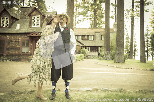 Image of 1920s Dressed Romantic Couple in Front of Old Cabin