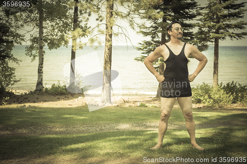 Image of Gentleman Dressed in 1920’s Era Swimsuit Holding Suitcases on 