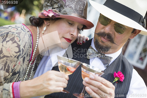 Image of Mixed-Race Couple Dressed in 1920’s Era Fashion Sipping Champa