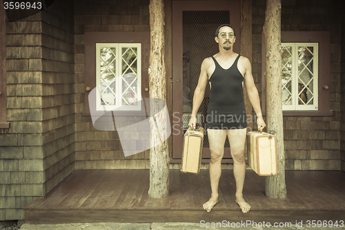 Image of Gentleman Dressed in 1920’s Era Swimsuit Holding Suitcases on 