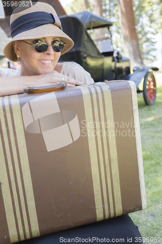 Image of 1920s Dressed Girl With Suitcase Near Vintage Car