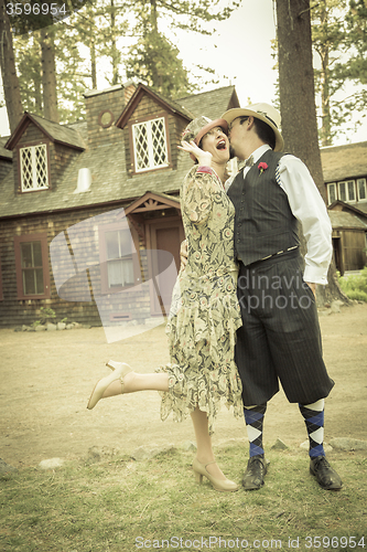 Image of 1920s Dressed Romantic Couple in Front of Old Cabin