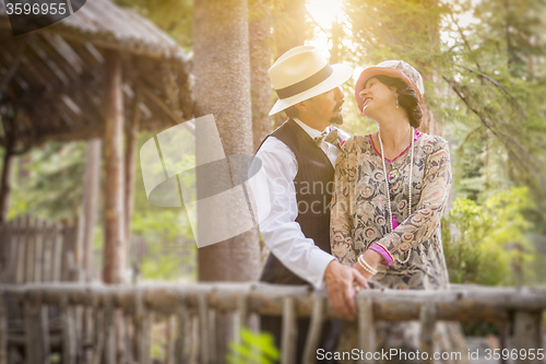 Image of 1920s Dressed Romantic Couple on Wooden Bridge