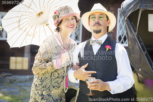 Image of Mixed-Race Couple Dressed in 1920’s Era Fashion Sipping Champa