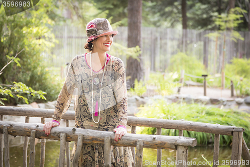 Image of 1920s Dressed Girl On Wooden Bridge Portrait