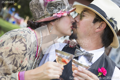 Image of Mixed-Race Couple Dressed in 1920’s Era Fashion Sipping Champa