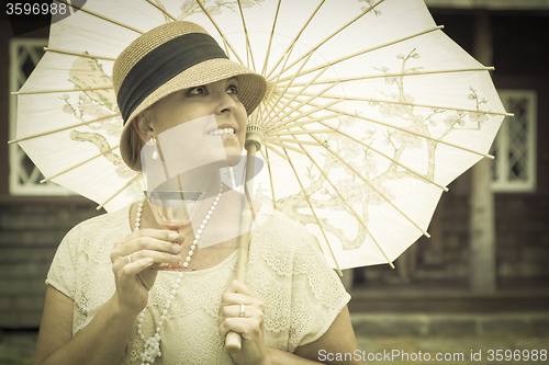 Image of 1920s Dressed Girl with Parasol and Glass of Wine Portrait