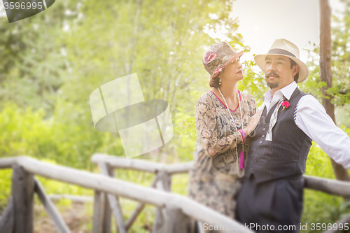 Image of 1920s Dressed Romantic Couple on Wooden Bridge