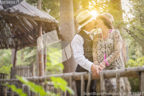 Image of 1920s Dressed Romantic Couple Kissing on Wooden Bridge