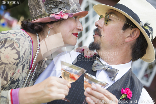 Image of Mixed-Race Couple Dressed in 1920’s Era Fashion Sipping Champa