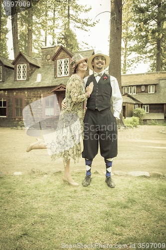 Image of 1920s Dressed Romantic Couple in Front of Old Cabin