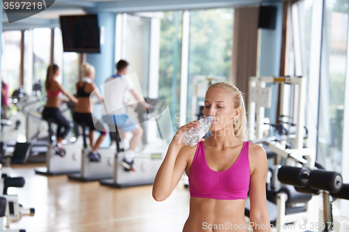Image of woman in fitness gym drink water