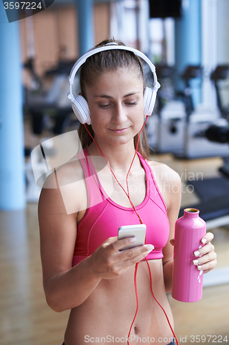 Image of woman with headphones in fitness gym