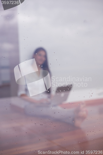 Image of relaxed young woman at home working on laptop computer