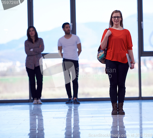 Image of student girl standing with laptop, people group passing by