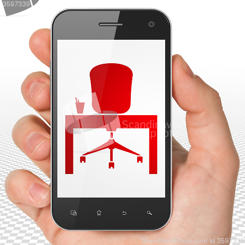 Image of Business concept: Hand Holding Smartphone with Office on display