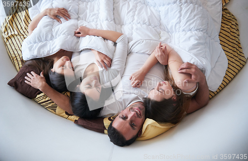 Image of handsome man in bed with three beautiful woman