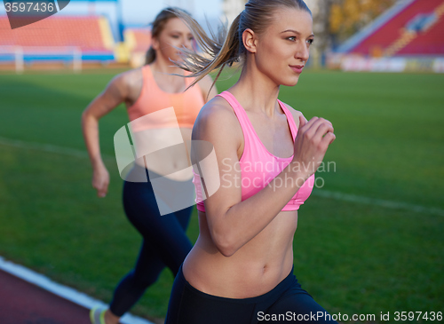 Image of athlete woman group  running on athletics race track