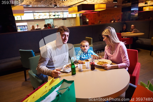 Image of family having lunch in shopping mall