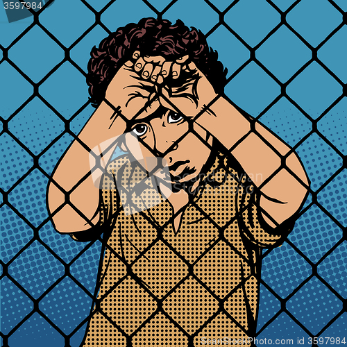 Image of Child boy refugee migrants behind bars the prison boundary