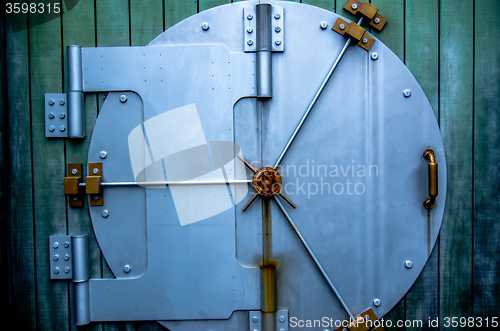 Image of security vault door on green wall