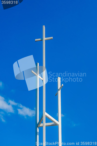 Image of Three trinity White Christian crosses in front of a cloudy sky w