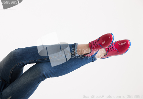 Image of Woman\'s Legs In Blue Jeans And Red Shoes