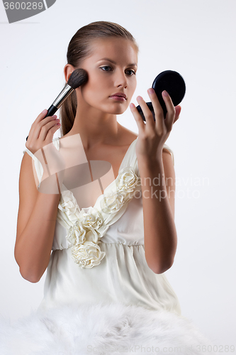 Image of Young Woman Applying Cosmetics