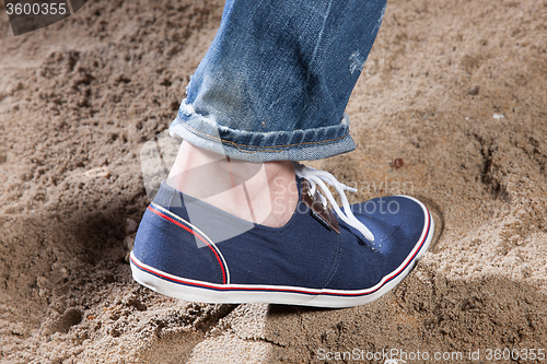 Image of Man\'s Legs And Footprint On The Sand