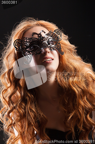 Image of Young Red- Haired Woman In A Black Mask
