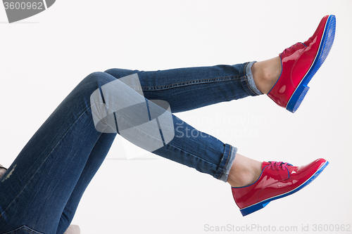 Image of Woman\'s Legs In Blue Jeans And Red Shoes
