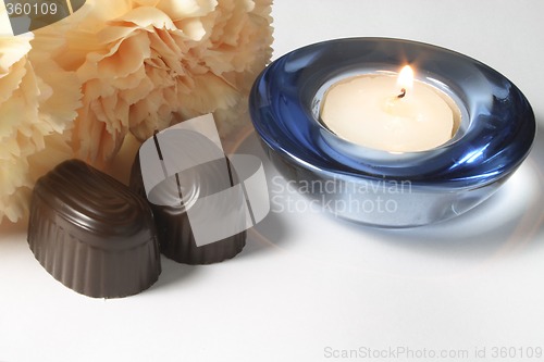 Image of chocolates and carnation with a candle