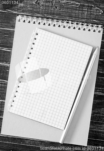 Image of note and pencil on wooden background