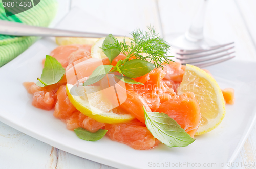 Image of fresh salmon with lemon on the white plate