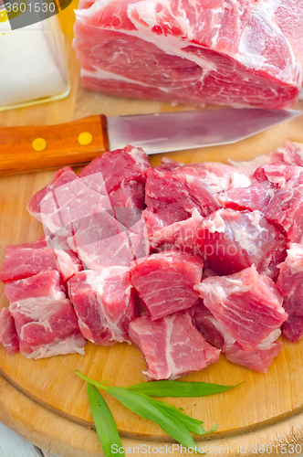 Image of raw meat and knife on the wooden board