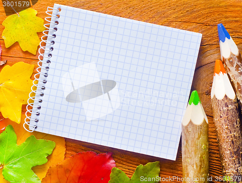 Image of leaves and note on wooden background